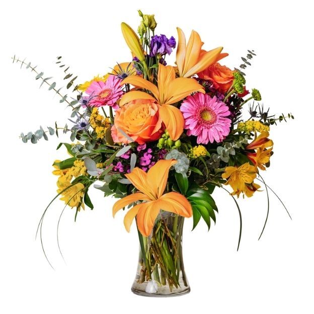 Bright floral arrangement with orange lilies, pink daisies, roses, and greenery in a glass vase
